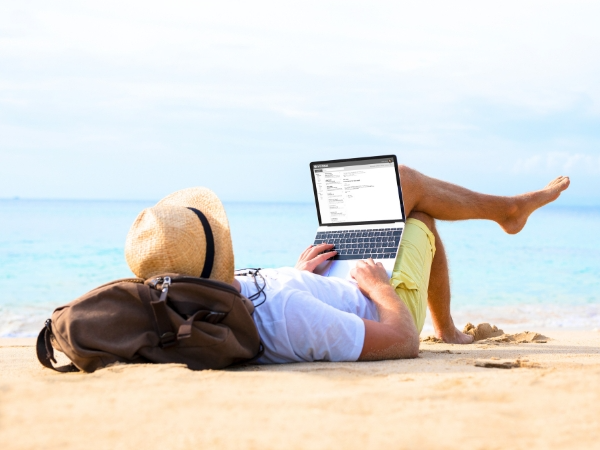 Man Working with Laptop on a Beach
