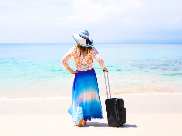 Woman Holding a Suitcase on a Beach