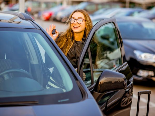 Woman with Rental Car at Airport Parking Lot